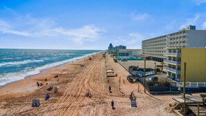 Ein Hotel direkt am Strand mit einem langen Sandstrand, einem Poolbereich und Blick auf den Ozean.