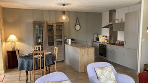 Cocina compacta con comedor, que incluye una mesa de madera, sillas y una pequeña isla.