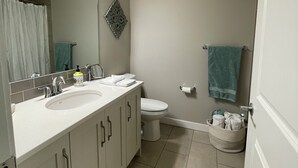 A bathroom with two sinks, a toilet, and a shower. - Two Bedroom Basement Suite (Calgary)