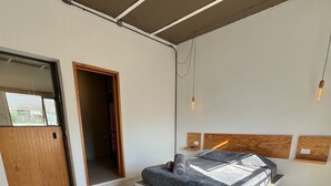 A bedroom with a bed, a bench, a geometric patterned floor, and a ceiling with exposed beams. - DOUBLE SUITE - S4 (Heroica Puebla de Zaragoza)