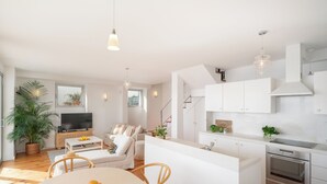 Una sala de estar moderna con televisor, sofá y comedor.