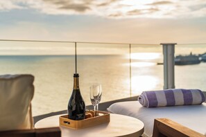 Ein Balkon mit Champagner, Gläsern und einem Handtuch.