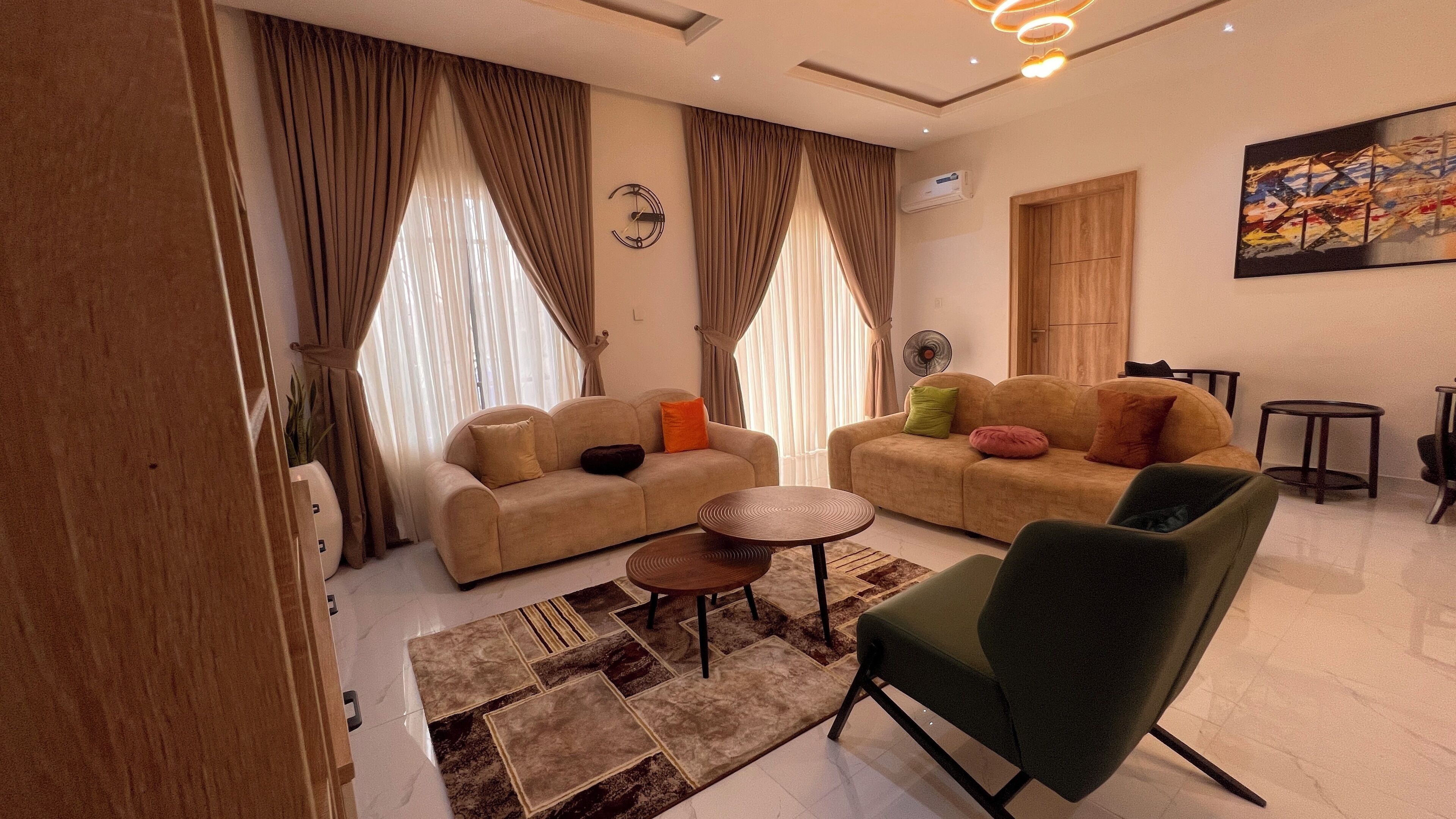 A modern living room with two sofas, a coffee table, and a green armchair.