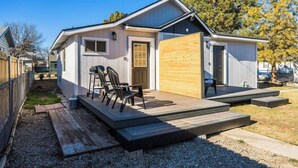 Ein Bungalow mit Terrasse und Sitzgelegenheit im Freien.