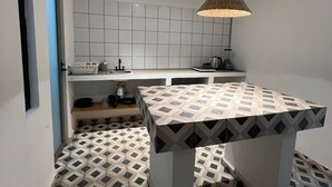 Et moderne køkken med et geometrisk gulvmønster, en central ø og en hængende lampe.