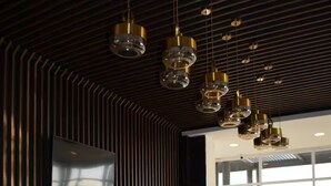A modern kitchen with a long dining table, wooden accents, and pendant lighting. - Charming apartment, incredible view (Zapopan)