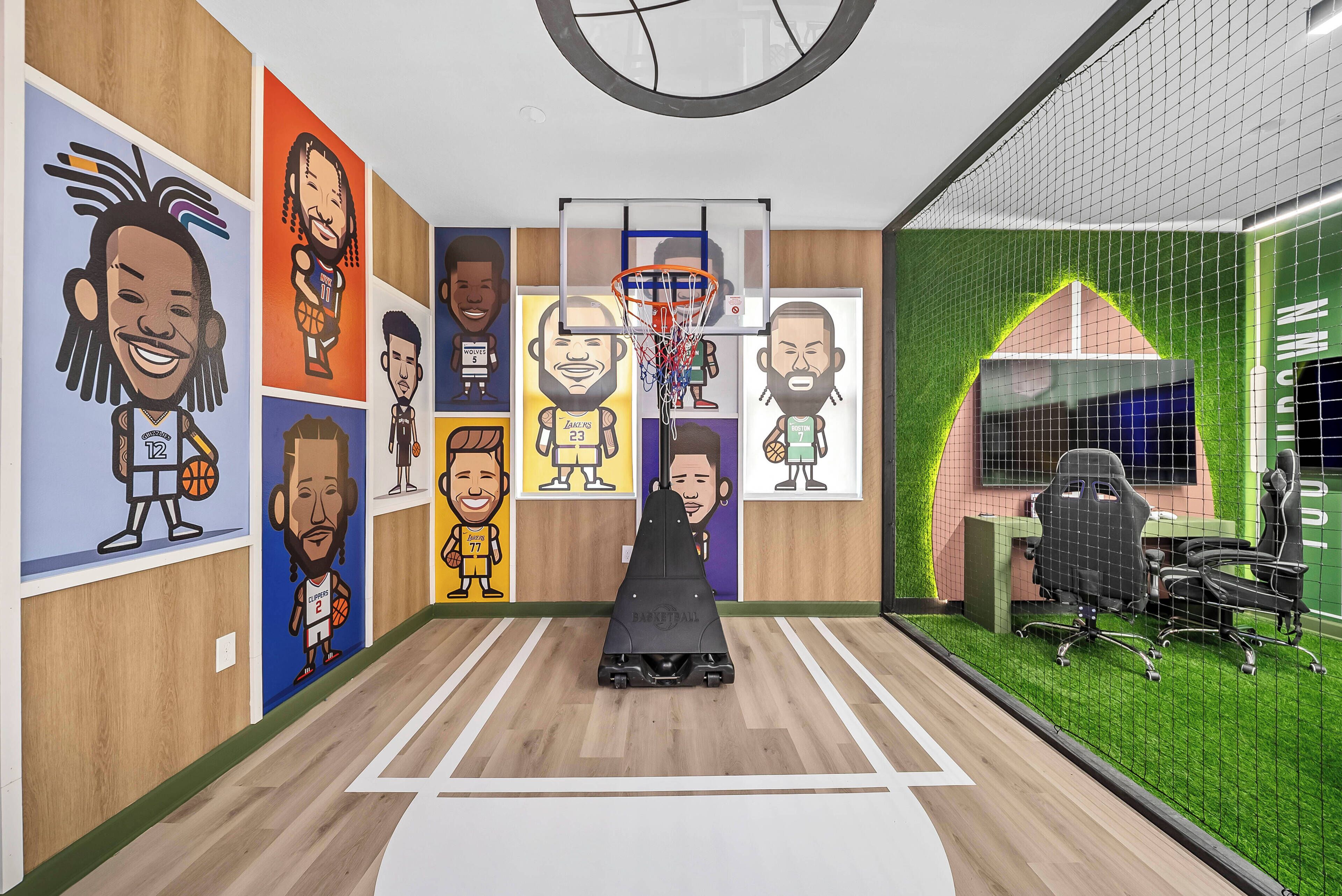 A basketball court with a hoop, surrounded by walls with cartoon character murals.