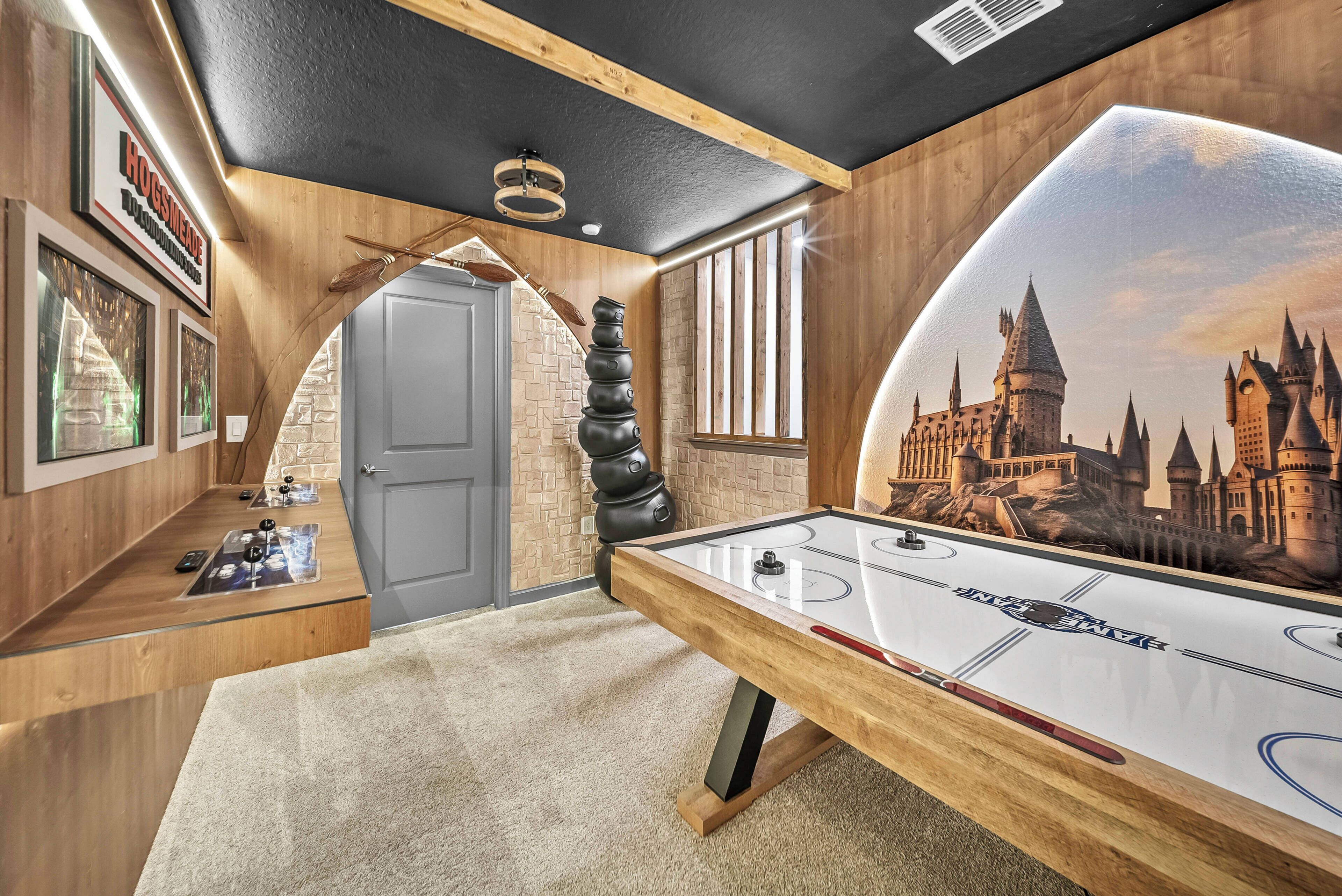 A room with a pool table, a mural of a castle, and a wooden ceiling.