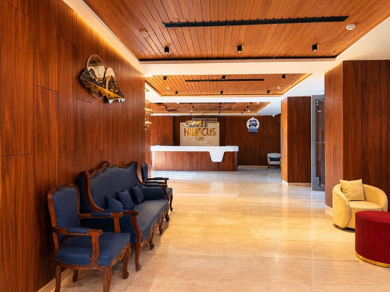 A lobby with wooden paneling, a reception desk, and seating arrangements.