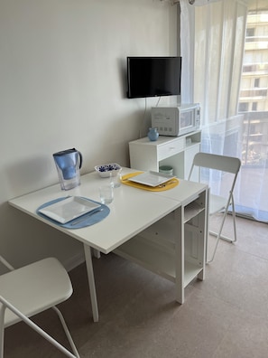 A white table with a TV, microwave, and a window with a view. - Superb T1 + Cabin sea view (Canet-en-Roussillon)