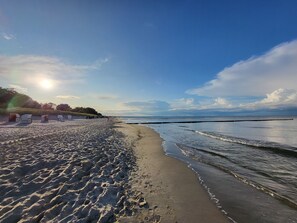 A beach with footprints, a row of beach chairs, and a calm sea under a clear sky. - Reethus for 6 adults & 2 small children, 3 bedrooms, 2 bathrooms, garden, sauna, fireplace, fenced (Zempin)