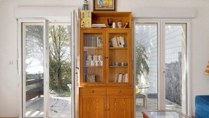 Une pièce avec un meuble en bois, une table en verre et un canapé bleu.