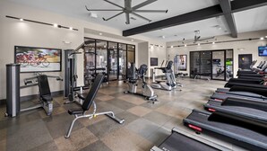 A modern gym with various exercise equipment, including treadmills, stationary bikes, and weight machines.