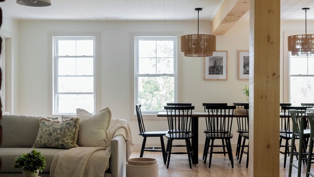 Un vaste espace de vie doté d’un plancher en bois, d’un canapé, d’une table basse et d’une table à manger avec des chaises.