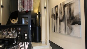 Un interior moderno con una cafetera, un cubo de basura y arte abstracto en la pared.