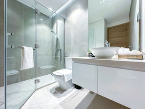 A modern bathroom with a glass-enclosed shower, a white toilet, and a large sink with a mirror above it. - Super Luxury Flat Design with Sea View (Dubai)