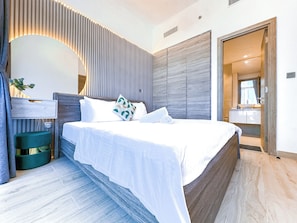 A modern bedroom with a large bed, a bedside table, a mirror, and a built-in wardrobe. - Super Luxury Flat Design with Sea View (Dubai)