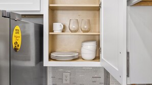 A kitchen with a built-in cabinet, a stainless steel refrigerator, and a wall socket. - Perfect 1-bedroom townhome with rooftop in charming Fort Worth (Fort Worth)