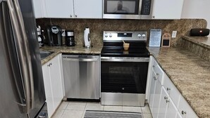 Una cucina moderna con elettrodomestici in acciaio inossidabile, un forno a microonde e una macchina per il caffè.