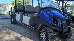 A blue golf cart with a covered seating area, large tires, and a Club Car logo. - bimini bay breezy sage 2/2 condo steps from pool beach clubhouse (Bailey Town)