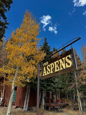 A wooden sign with the text 'THE ASPENS' indicating a location or establishment. - Mogul Manor-3B Giant Steps (Brian Head)