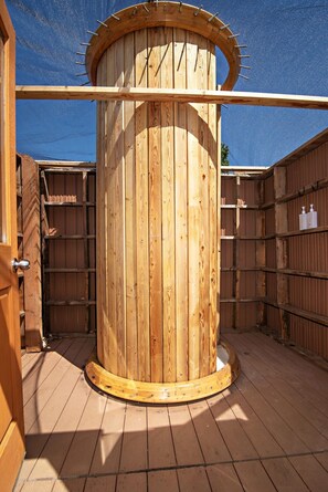A wooden cylindrical structure with a door, surrounded by wooden walls and a wooden deck. - Yurt #8 - Glamping by the Gorge & Cave B (Quincy)