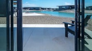 Ein modernes Gebäude mit großen Glasüren, die zu einem Poolbereich führen.