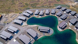 An aerial view of a residential area with multiple detached houses arranged in a semi-circular pattern around a central green space. - The Point at the Lakes - Cave B (Quincy)