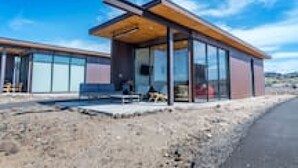 Un bâtiment moderne doté de grandes fenêtres en verre et d’une structure de toit en bois.