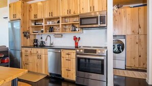 A modern kitchen with wooden cabinets, stainless steel appliances, and a central island.