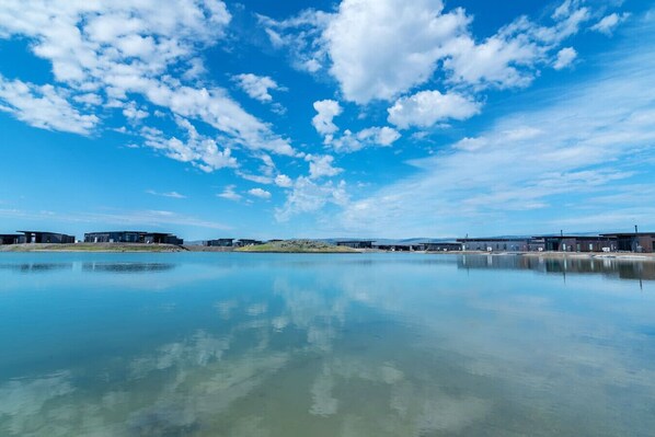Een groot, open waterlichaam dat de lucht en gebouwen weerspiegelt.