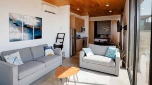 A modern living room with two sofas, a coffee table, and artwork on the walls. - Wine Down in 3C at Cave B Ridge (Quincy)