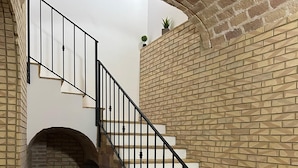 A staircase with a brick wall and a wooden floor leading to an upper level. - Double room with private bathroom and balcony (Spoltore)