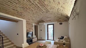 A dining area with a brick ceiling, a wooden table, and white chairs. - Double room with private bathroom and balcony (Spoltore)