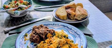 A table set with breakfast dishes, a coffee cup, and a view of the ocean.