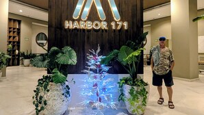A modern hotel entrance with a wooden facade and illuminated signage reading "HARBOR 171". - Charming oseanfront, New appartment (Puerto Vallarta)