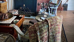A traditional living room with a fireplace, a wooden coffee table, a patterned armchair, and a blue chair. - Rustic 5-Bedroom Home on 140 Acres perfect for White Mountain family getaways (Campton)