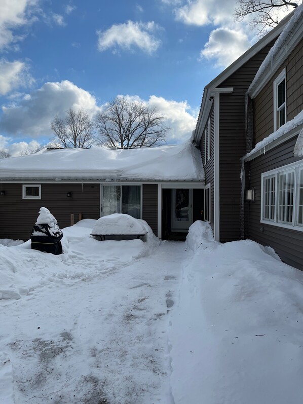 A residential area with a house covered in snow, a garage, and a driveway. - Rustic 5-Bedroom Home on 140 Acres perfect for White Mountain family getaways (Campton)