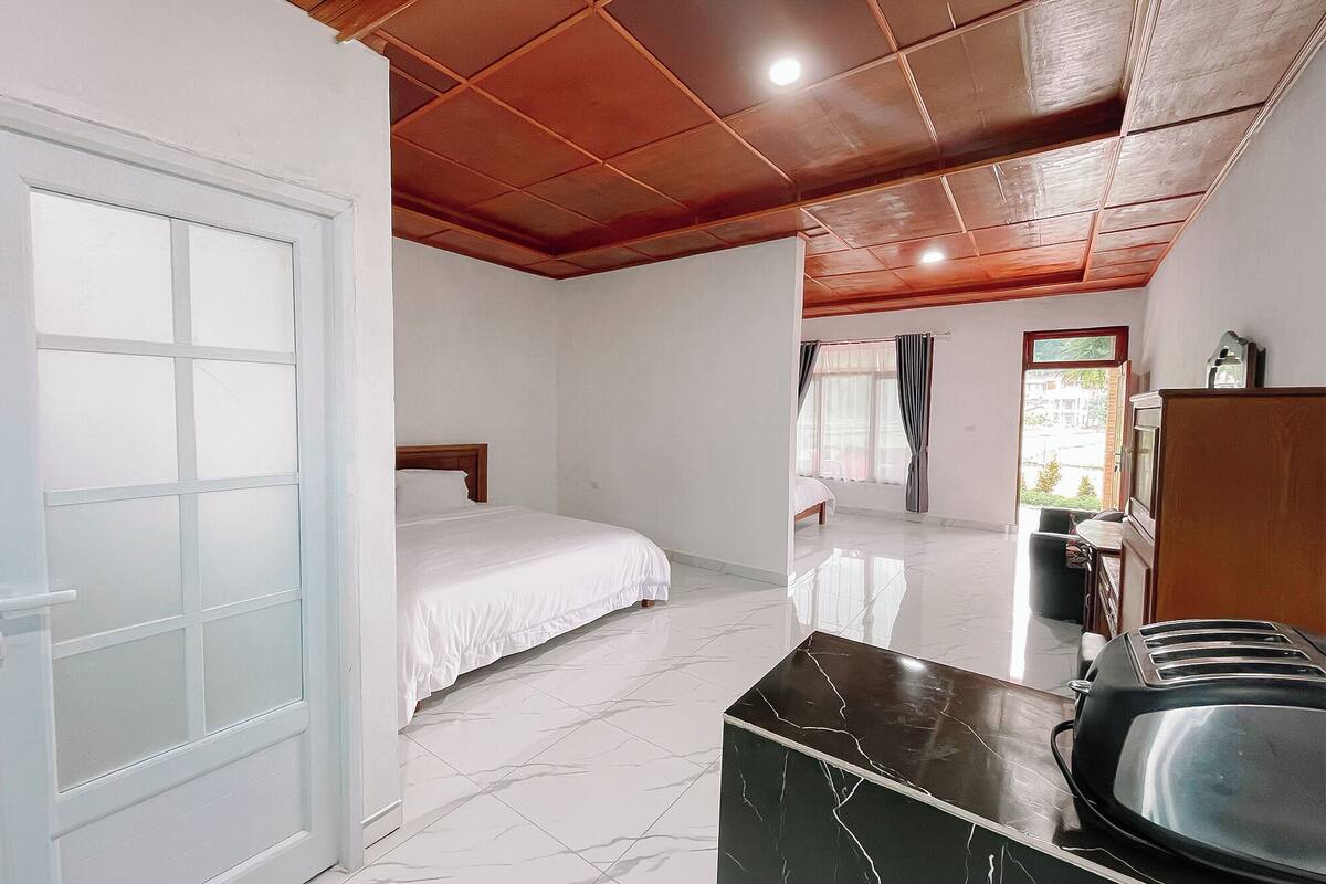 Una habitación de hotel con una cama, un escritorio y vistas al exterior.