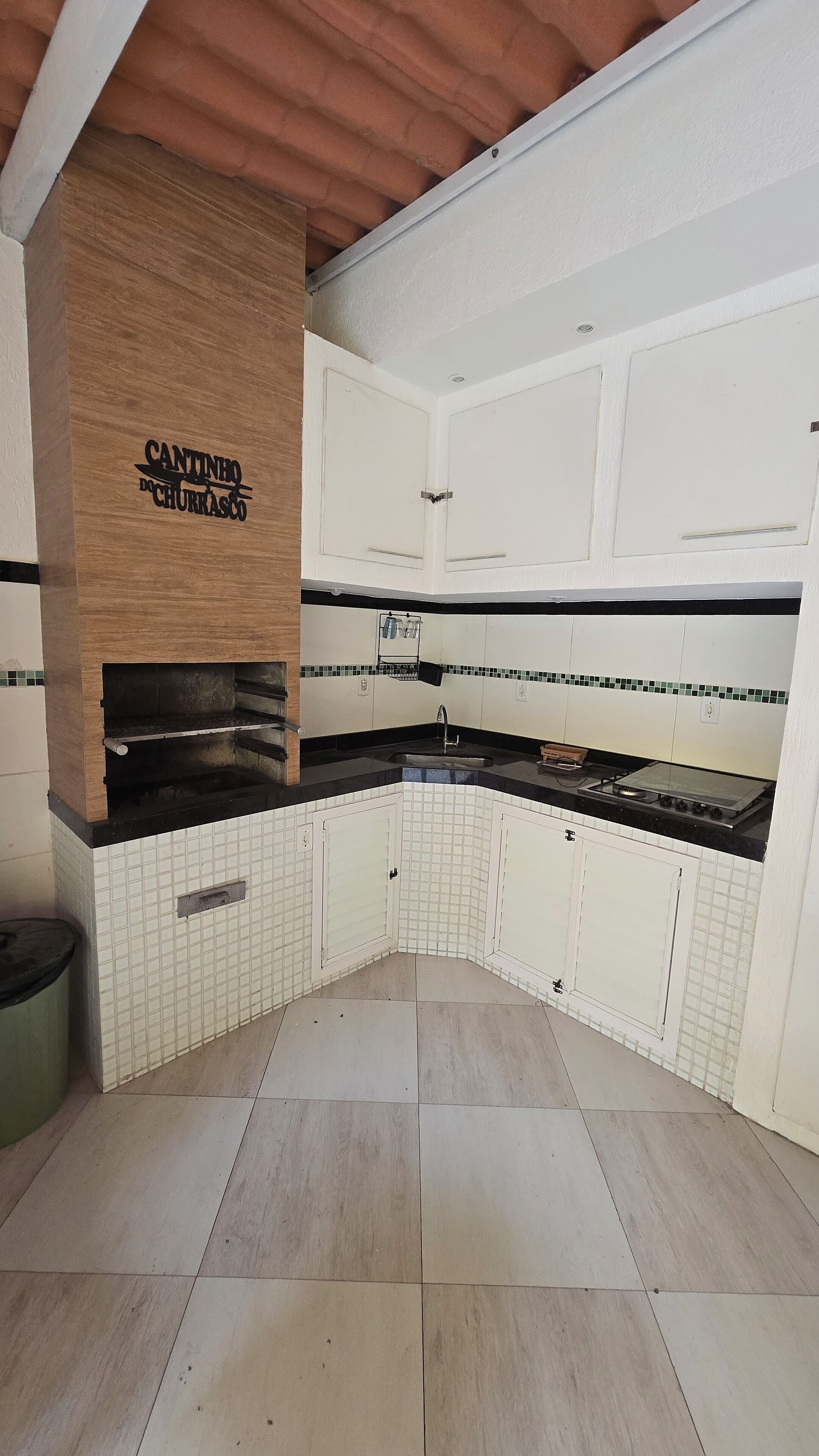 A kitchen with white cabinets, a black countertop, and a tiled backsplash.