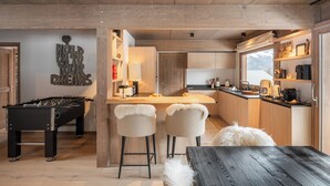 A cozy kitchen with wooden accents, a bar area, and a foosball table. - Chalet Quatre Coeurs with sauna in Saint Gervais (Saint-Gervais-les-Bains)