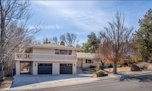 A two-story house with a garage, a balcony, and a driveway.