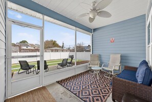 A covered patio with a ceiling fan, outdoor seating, and a view of the neighborhood. - Beach House - Tropic Like It's Hot (Panama City Beach)