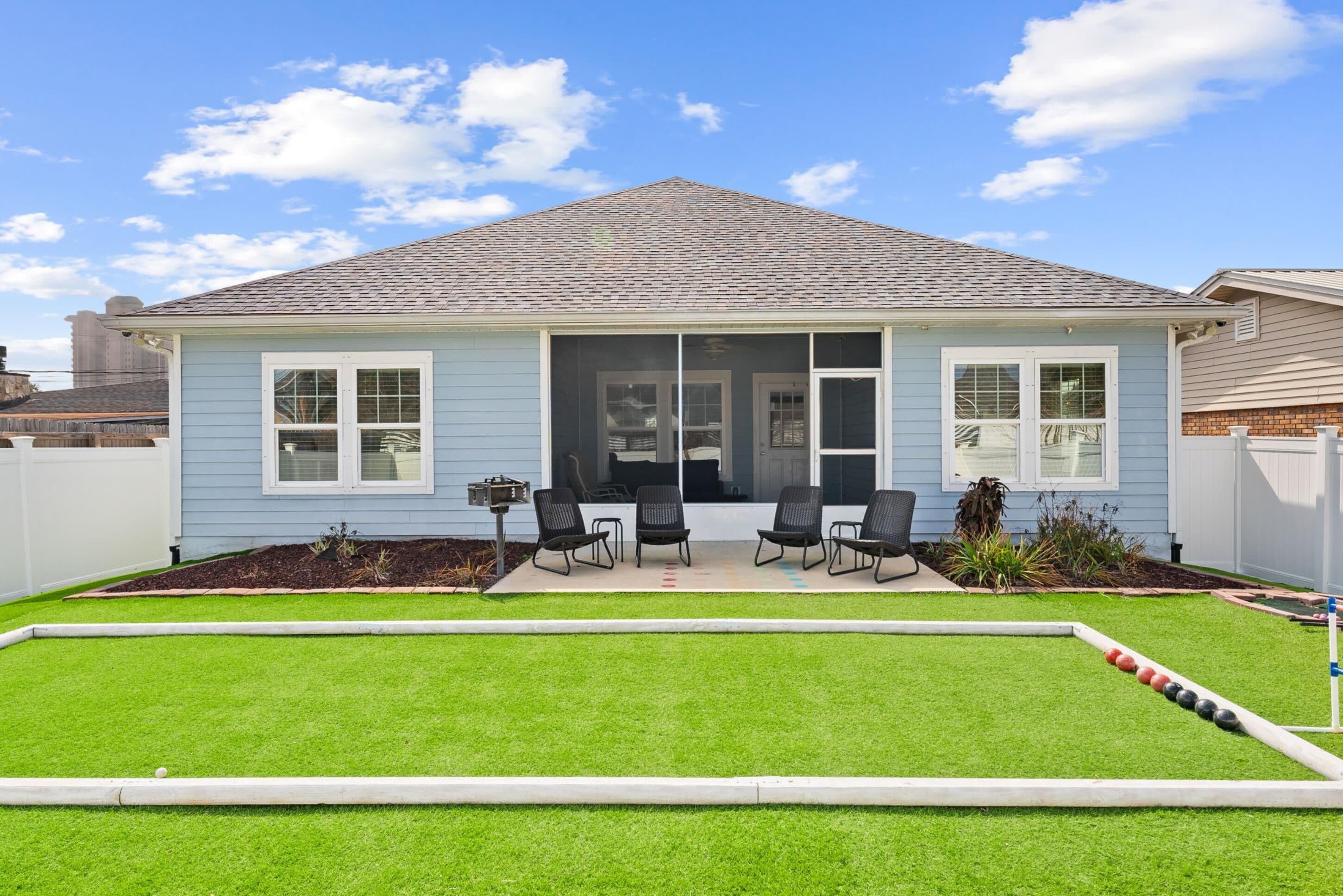 A single-story house with a front porch, a small patio area, and a well-maintained lawn.