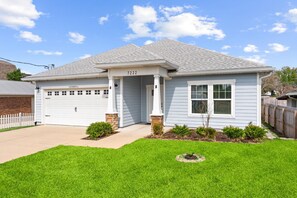 A single-story house with a garage, a covered porch, and a well-maintained lawn. - Beach House - Tropic Like It's Hot (Panama City Beach)