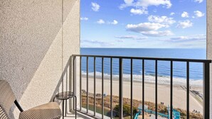 Uma varanda com vista para a praia e o oceano.
