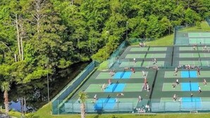 Un complexe de courts de tennis en plein air, entouré d’une végétation luxuriante.