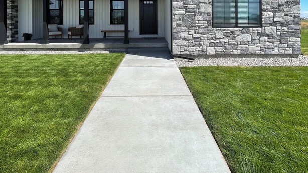A two-story house with a stone facade and a covered porch. - 4 bedrooms & attached bathrooms, EV charge, water purifier, gas fireplace, games (Rexburg)
