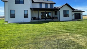 A modern two-story house with a covered porch and a garage. - 4 bedrooms & attached bathrooms, EV charge, water purifier, gas fireplace, games (Rexburg)