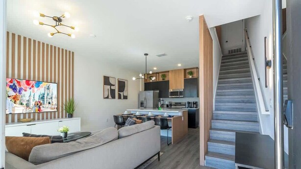 Un appartement moderne comprenant un espace de vie, une cuisine et un escalier.